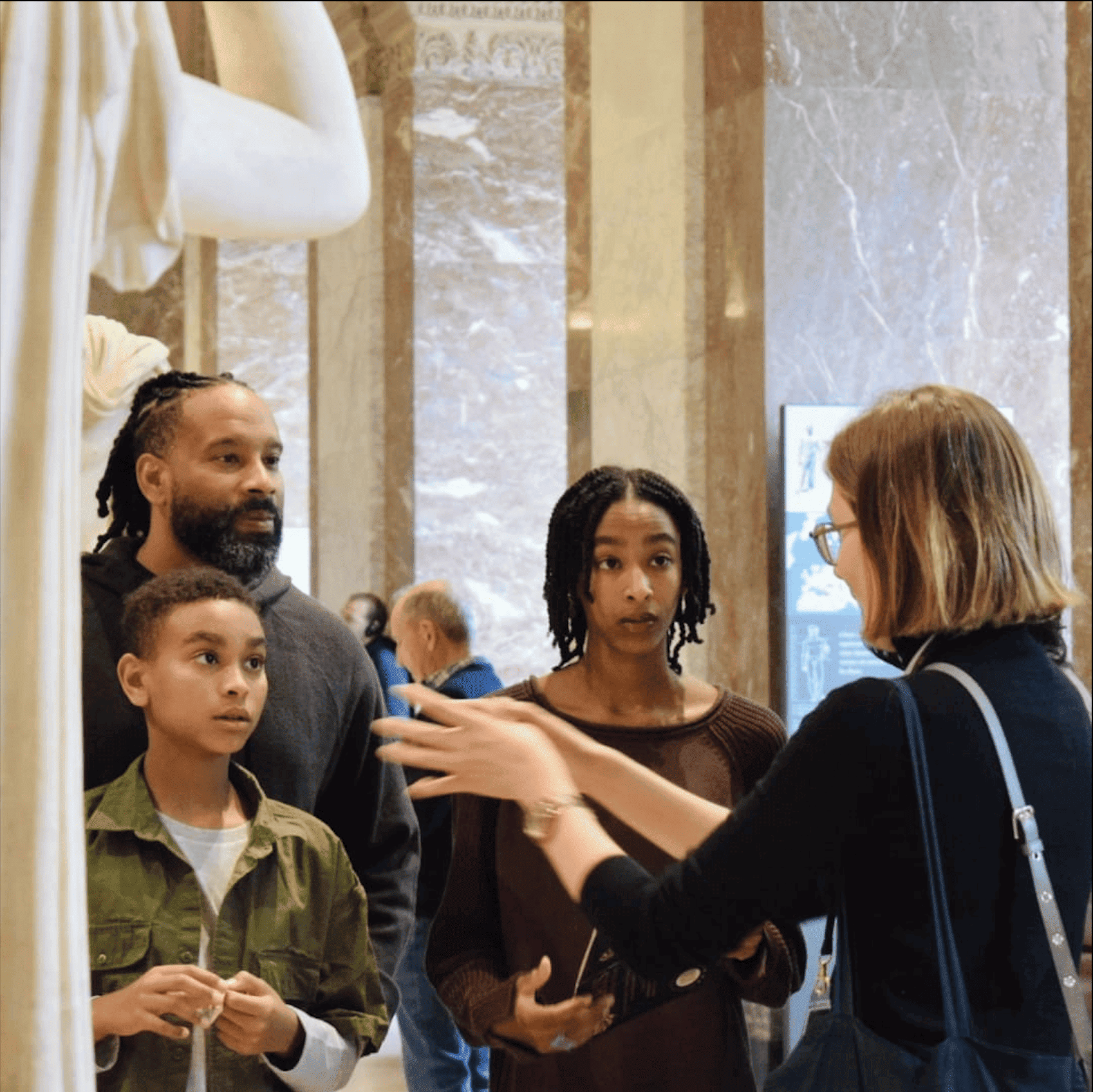 Family looking at guide Kotryna, captivated by the story